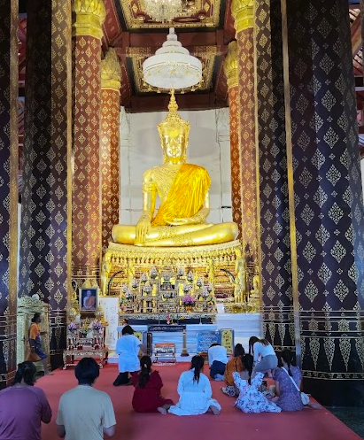 Imagem de Buda adornada com trajes reais no Wat Na Phra Men