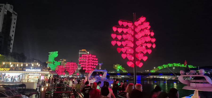 Love Bridge iluminada com a Dragon Bridge ao fundo, em Da Nang, no Vietnã